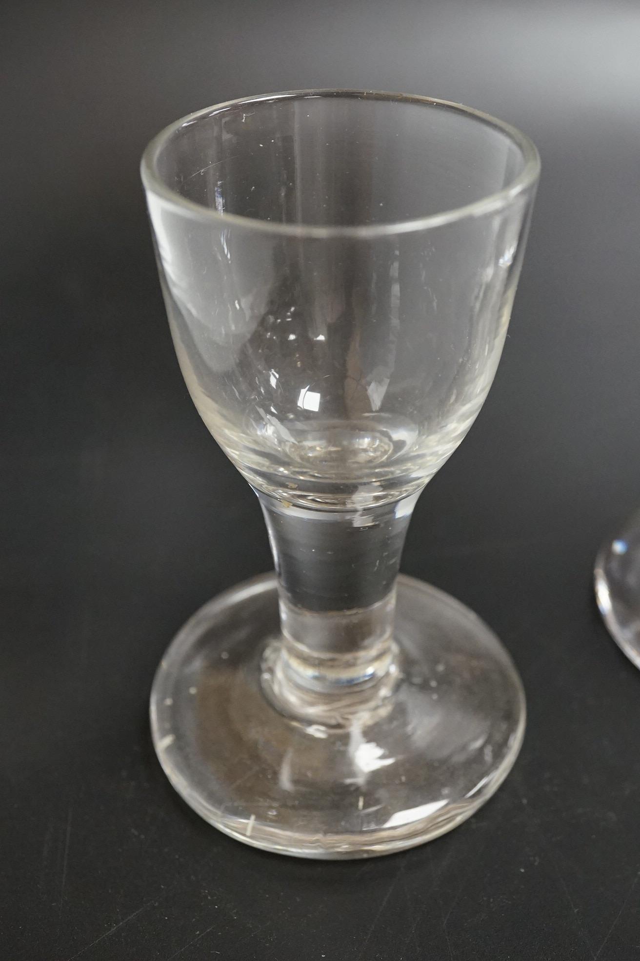 Two George III firing glasses, one with DSOT stem, together with a gin glass with engraved bowl, tallest 11.5cm high (3)
